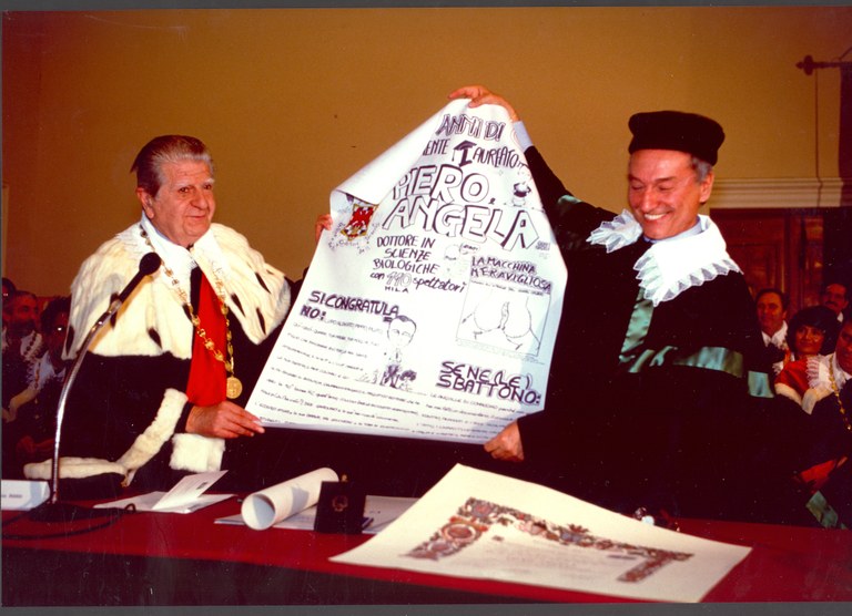 Piero angela Antonio Rossi cartellone.jpg Piero Angela con il già Rettore Antonio Rossi in un passaggio giocoso della cerimonia del 1992